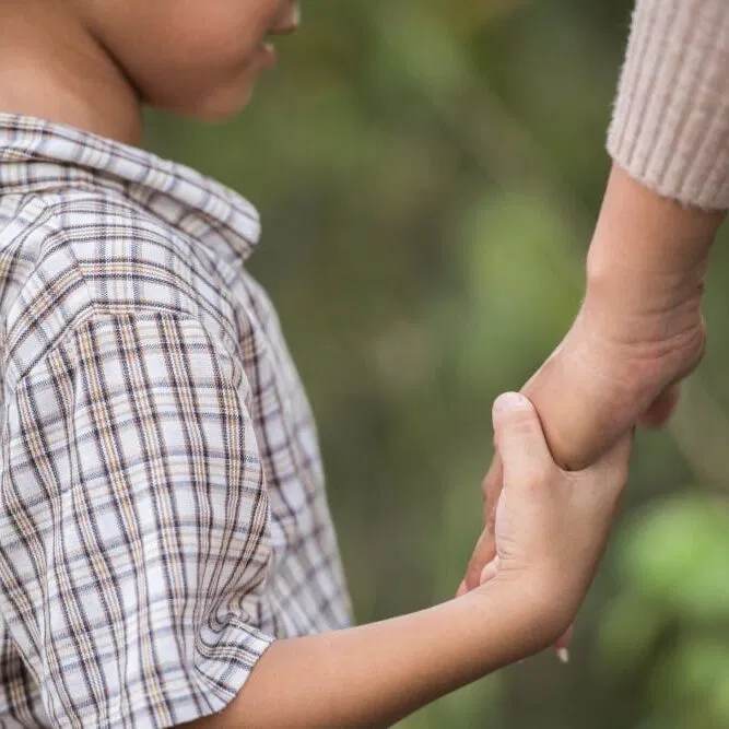 child holding hands with an adult